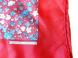 a red pocket square with blue and white flowers on it