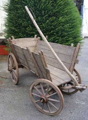 a small wooden cart with a wooden handle on the street