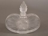 a clear glass heart shaped bottle with a leaf on it
