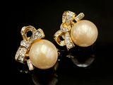 une paire de boucles d'oreilles en perles et diamants sur fond noir