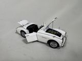a white toy car with a open hood on a white surface
