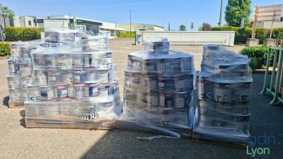 many cans of water sitting on a pallet in the parking lot