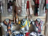 many different scarves and scarves on display in a store