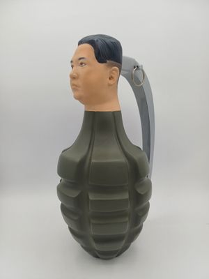 une image représentant un vase vert en forme de grenade surmonté d'une tête d'homme