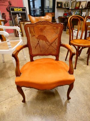 an orange chair that is sitting in the middle of a room