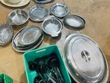 a lot of silverware on a table with a green container