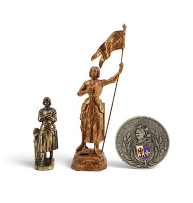 une petite statue représentant une femme tenant un drapeau à côté d'une pièce de monnaie