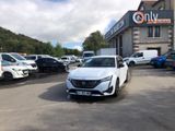 une voiture blanche garée sur un parking devant un immeuble