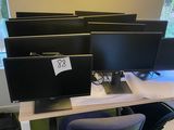 four computer screens on a desk in a room