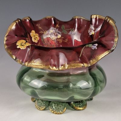 a green vase with a red flower inside of it
