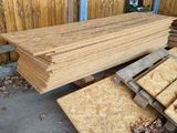 a pile of lumber sitting on the ground in front of a fence