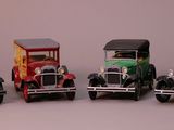 several toy cars are lined up in a row on a gray surface