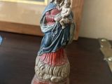 une figurine représentant une femme tenant un enfant dans ses bras, posée sur une table
