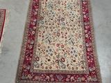 a close up of a rug on a floor with a chair in the background