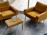 deux chaises et un pouf devant une porte vitrée