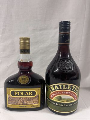 deux bouteilles d'alcool posées l'une à côté de l'autre sur une table