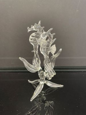 une figurine en verre représentant un poisson, posée sur une table