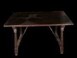 an old wooden table with a black top on a black background