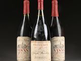 three bottles of red wine sitting on top of a table