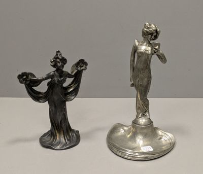 pair of silver figurines of a woman and a man on a pedestal