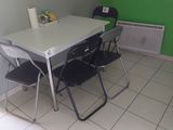 une table et des chaises dans une pièce dont l'un des murs est vert