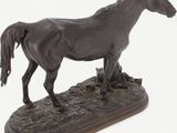 statue of a horse standing on a wooden base on a white background