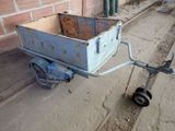 a small cart with a wheel attached to the side of a building