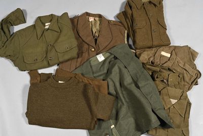 un tas de vêtements militaires posé sur une surface blanche
