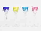 six different colored wine glasses are lined up in a row