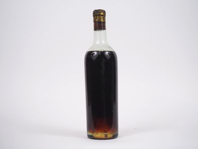 une bouteille d'alcool posée sur une surface blanche