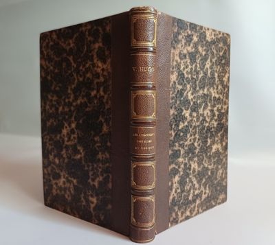 an old book sitting on top of a white table next to a white wall