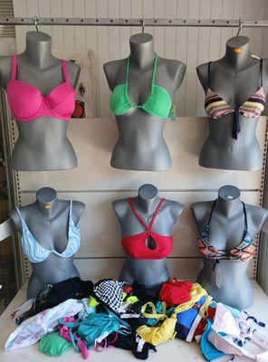 several mannequins are lined up on a shelf in a room