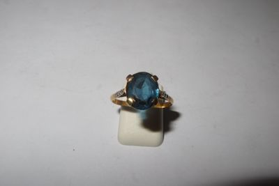 a close up of a ring with a blue stone in it