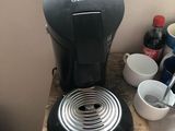 a coffee maker sitting on a counter next to a cup of coffee