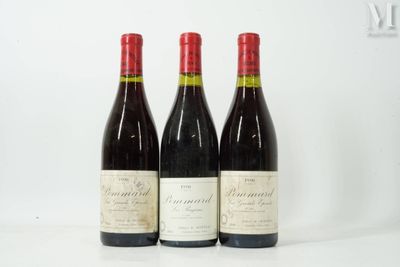 three bottles of red wine sit on a white surface