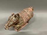 a figurine of a horse with a blanket on it ' s back