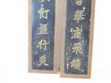 two signs with chinese writing on them hanging on a wall