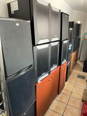 several refrigerators and freezers are lined up in a room