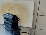a black coffee maker sitting on a counter in a kitchen