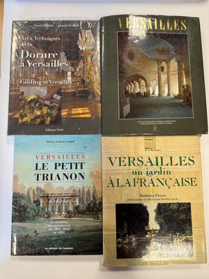 trois livres sont posés sur une table devant un ordinateur portable