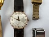 three watches and a watch band on a table