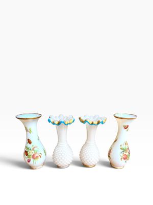 three white vases with floral designs are lined up against a white background
