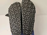 the soles of a pair of black shoes on a blue box