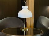 two chairs and a table in a room with a lamp on top of it