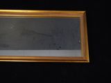 a picture of a gold framed mirror on a black wall