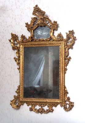 un miroir dans lequel on voit un voilier, accroché au mur