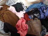 a pile of clothes in a suitcase on a bed