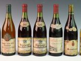 six bottles of wine are lined up in a row on a table