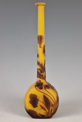 a yellow and brown vase with a flower design on it