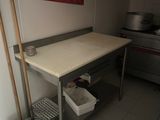 une table sur laquelle sont posés une serpillière et des seaux, dans une cuisine